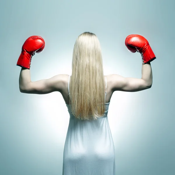 Woman back in white dress with red boxing gloves. Boxer bride