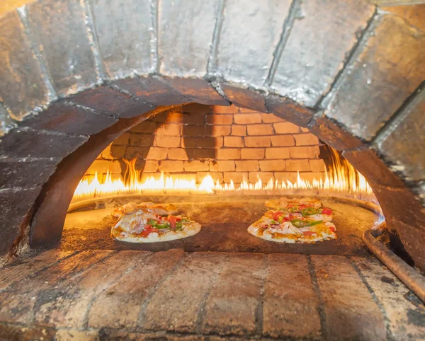 Pizzas cooking in an open oven