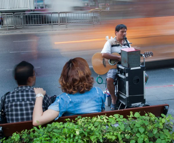 Playing guitar, singing blind beggar in the street car