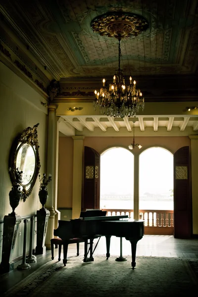 Piano room with yellow walls and many windows