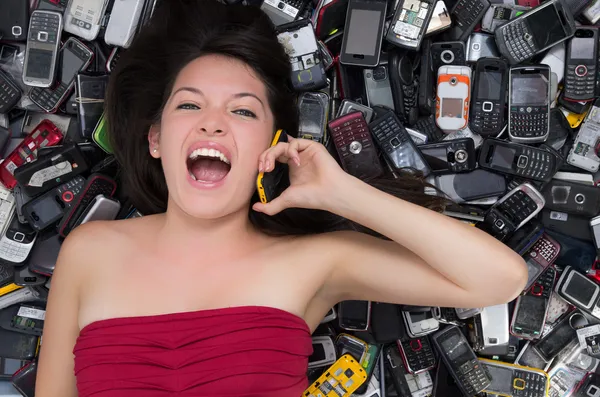 Woman on top of a Pile of mobile cell phones
