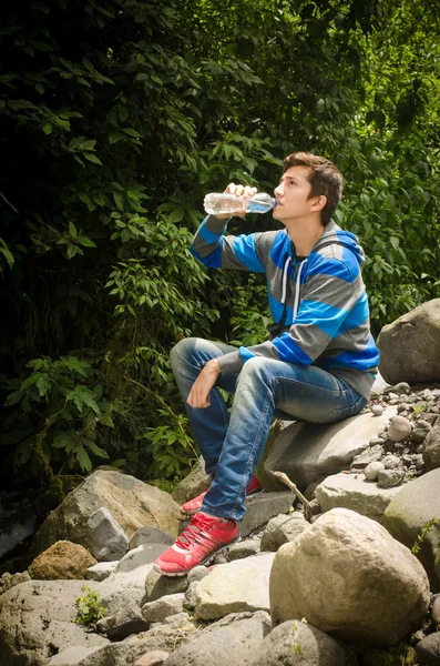 Man drinking water outdoors in the jungle