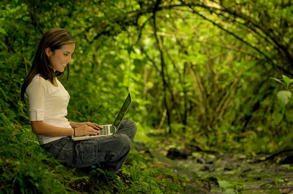 Woman in the forest using a laptop