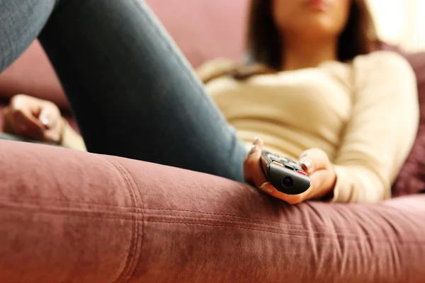 Female hand holding remote control