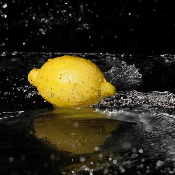 Fresh water drops on lemon on black background