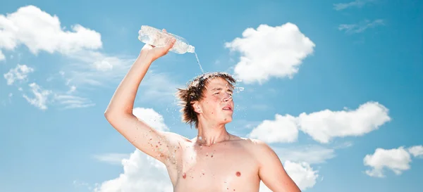 Young exhausted athlete splashing and pouring fresh water on his