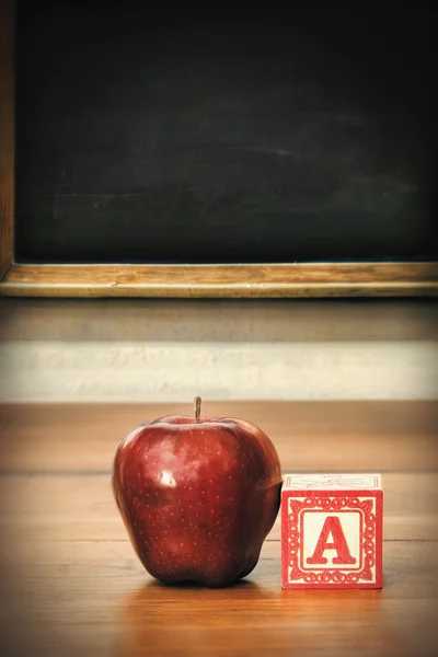 Delicious red apple on school desk