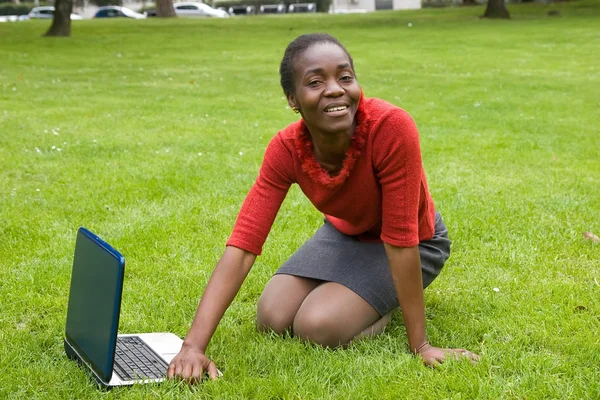 Woman on grass with laptop
