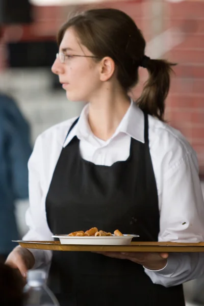 Waitress carries a tray of food