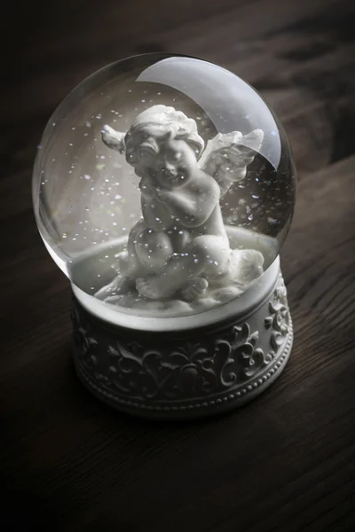 Snow globe with snow flakes and angel