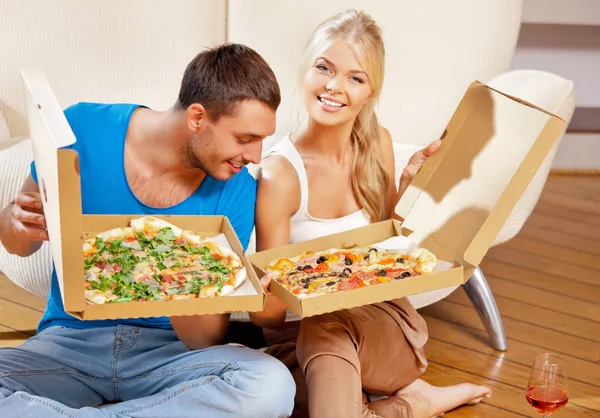 Romantic couple eating pizza at home