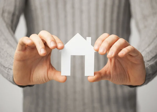 Man holding paper house