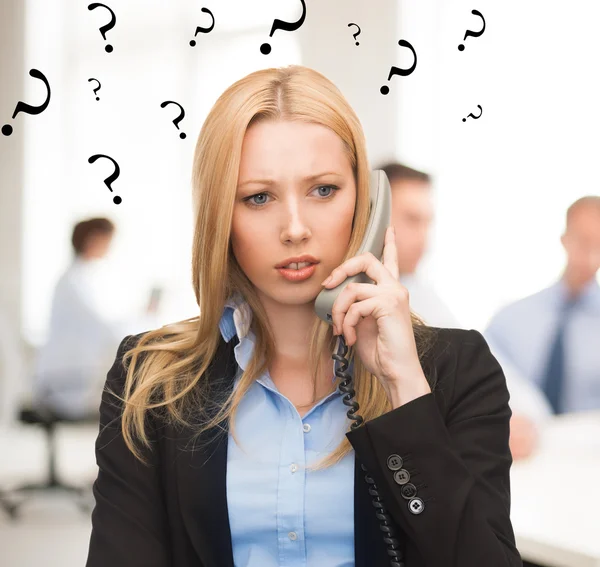 Confused woman with phone in office