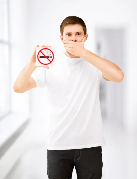 Young man holding no smoking sign