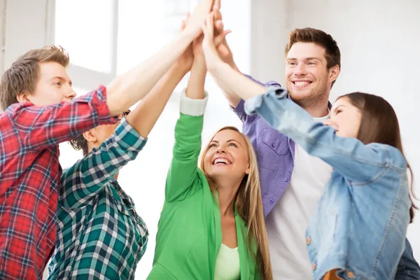 Happy students giving high five at school