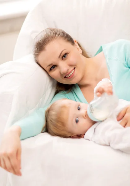 Mother and adorable baby with feeding-bottle — Stock Photo #29003755