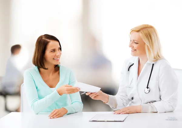 Doctor giving prescription to patient in hospital