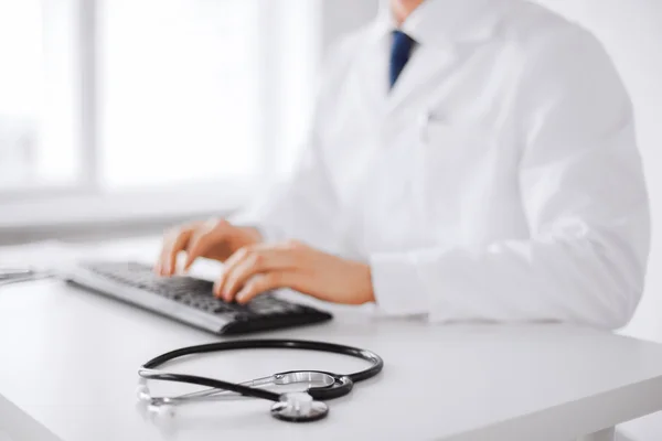 Male doctor typing on the keyboard