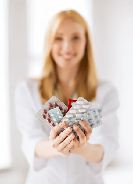 Female doctor with packs of pills