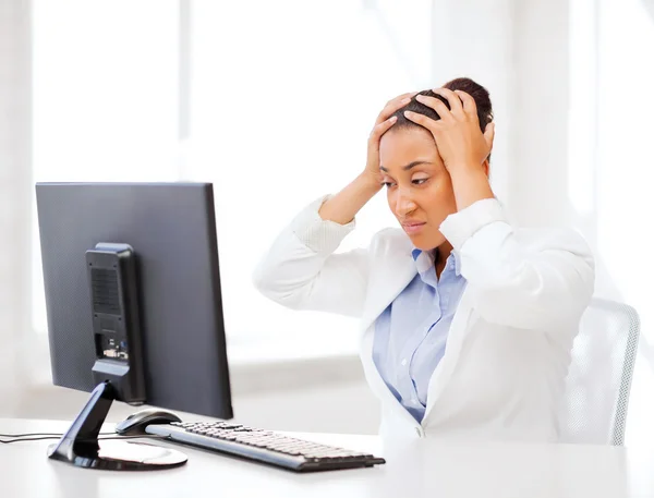 Stressed african woman with computer