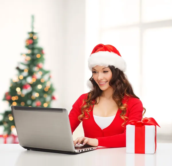 Woman with gift box and laptop computer