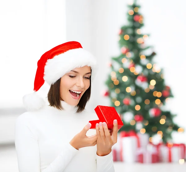 Surprised woman in santa helper hat with gift box