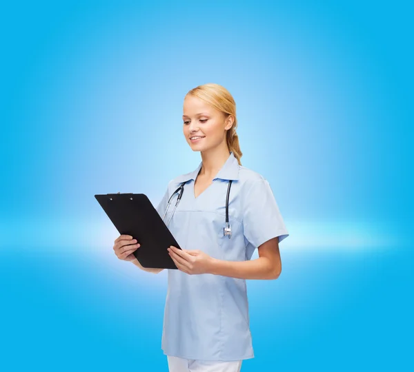 Smiling female doctor or nurse with clipboard