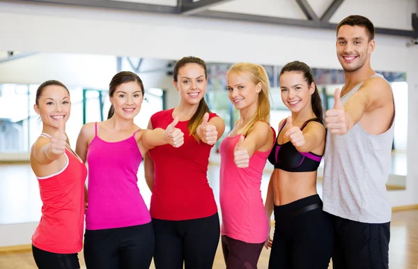 Group of people in the gym showing thumbs up