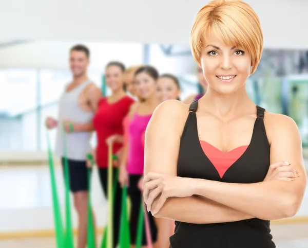 Group of smiling people exercising in the gym