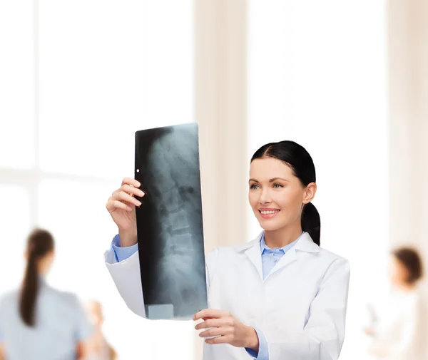 Smiling female doctor looking at x-ray