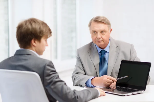 Older man and young man with laptop computer