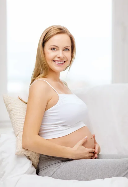 Happy pregnant woman touching her belly