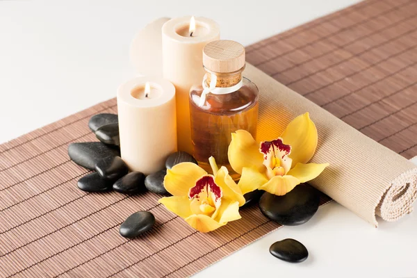 Essential oil, massage stones and orchid flower
