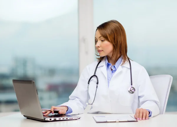 Busy doctor with laptop computer and clipboard