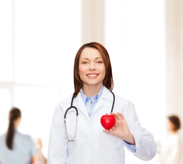 Smiling female doctor with heart and stethoscope