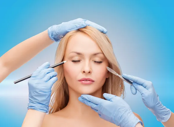 Woman and beautician hands with pencil and scalpel