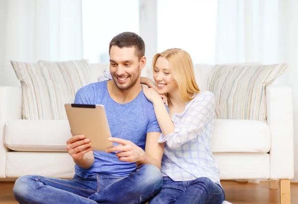 Smiling happy couple with tablet pc at home