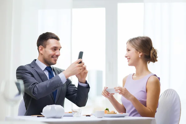 Smiling couple with sushi and smartphones