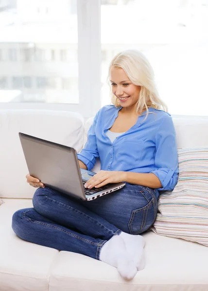 Smiling woman with laptop computer at home