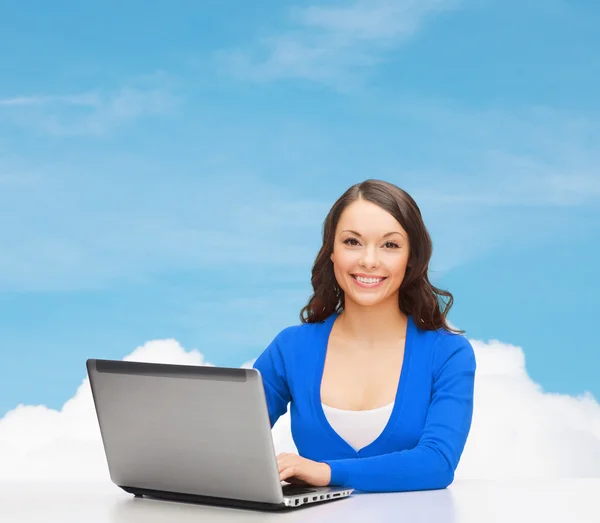 Smiling woman in blue clothes with laptop computer