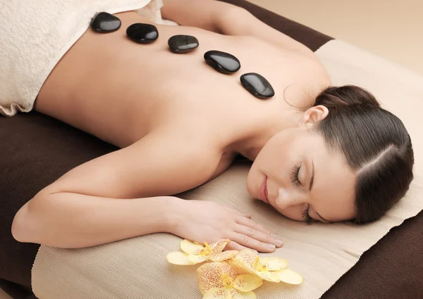 Asian woman in spa with hot stones