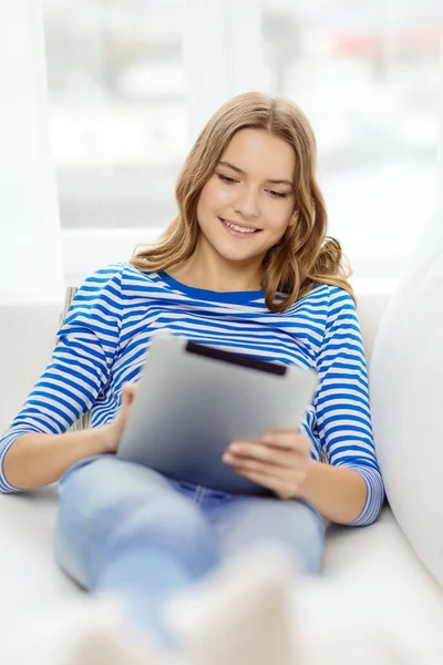 Smiling teenage girl with tablet pc at home