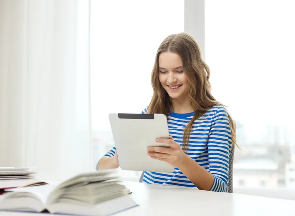 Smiling student girl with tablet pc and books