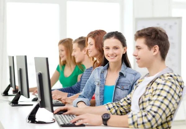 Smiling student with computer studying at school