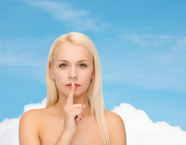 Calm young woman with finger on lips