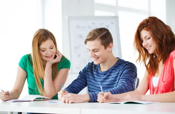 Smiling students with textbooks at school