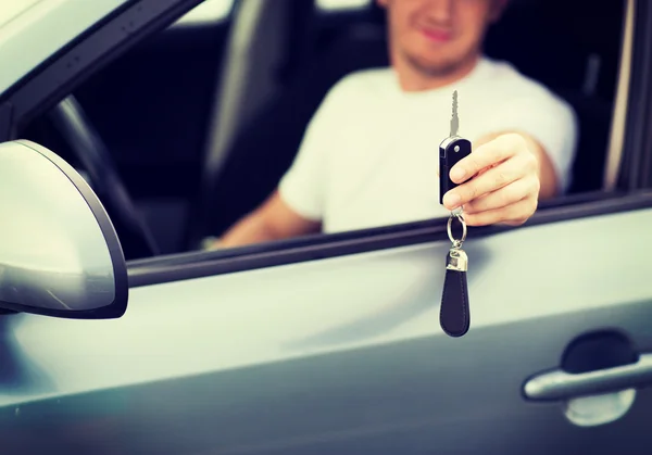 Man with car key outside