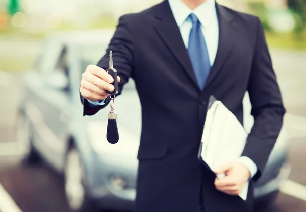 Man with car key outside