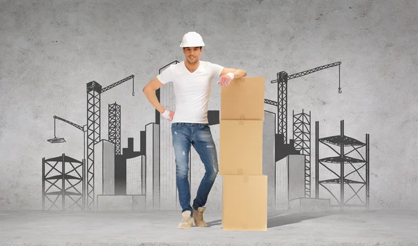 Man in helmet with tower of cardboard boxes