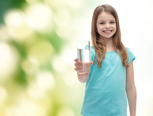 Smiling little girl giving glass of water